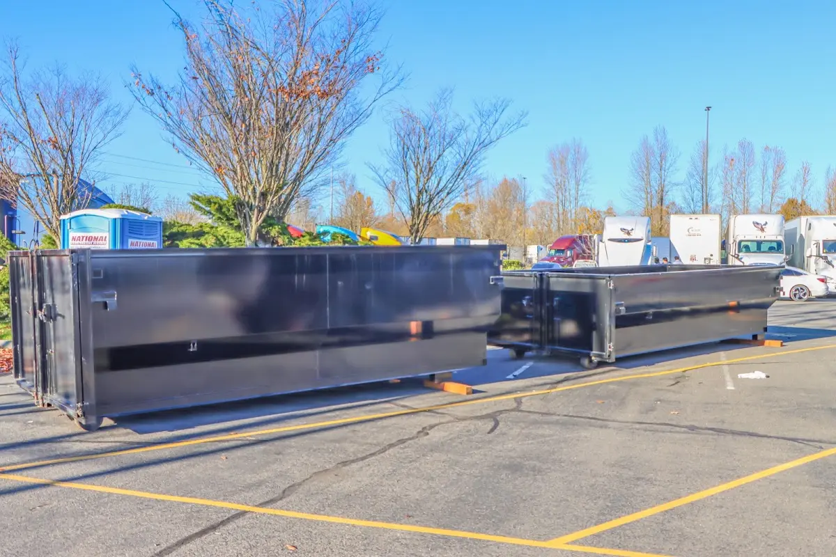 Professional dumpster rental service with roll-off container on residential driveway in Peters